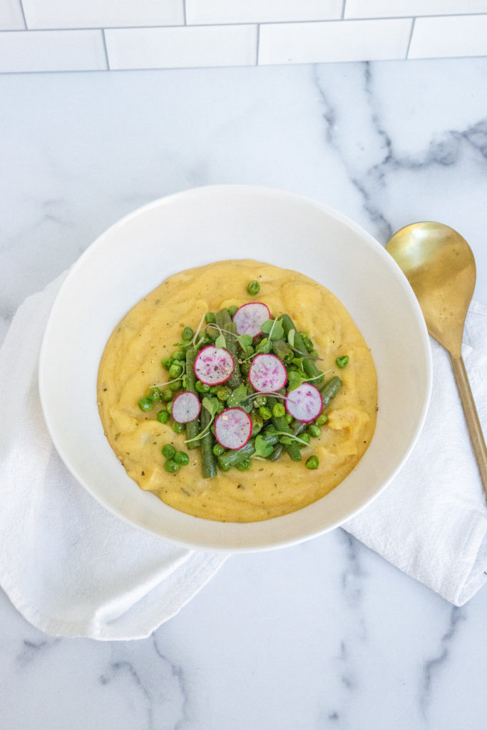 creamy vegetable polenta with green beans, radish, and sprouts