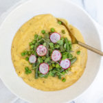 creamy vegetable polenta with green beans, radish, and sprouts