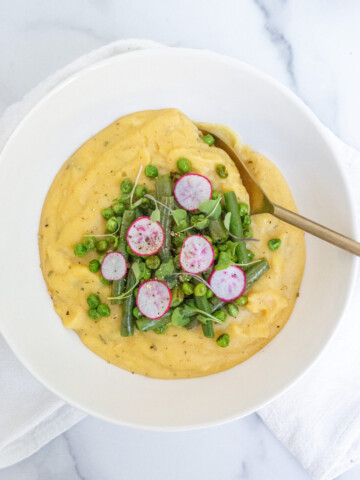 creamy vegetable polenta with green beans, radish, and sprouts