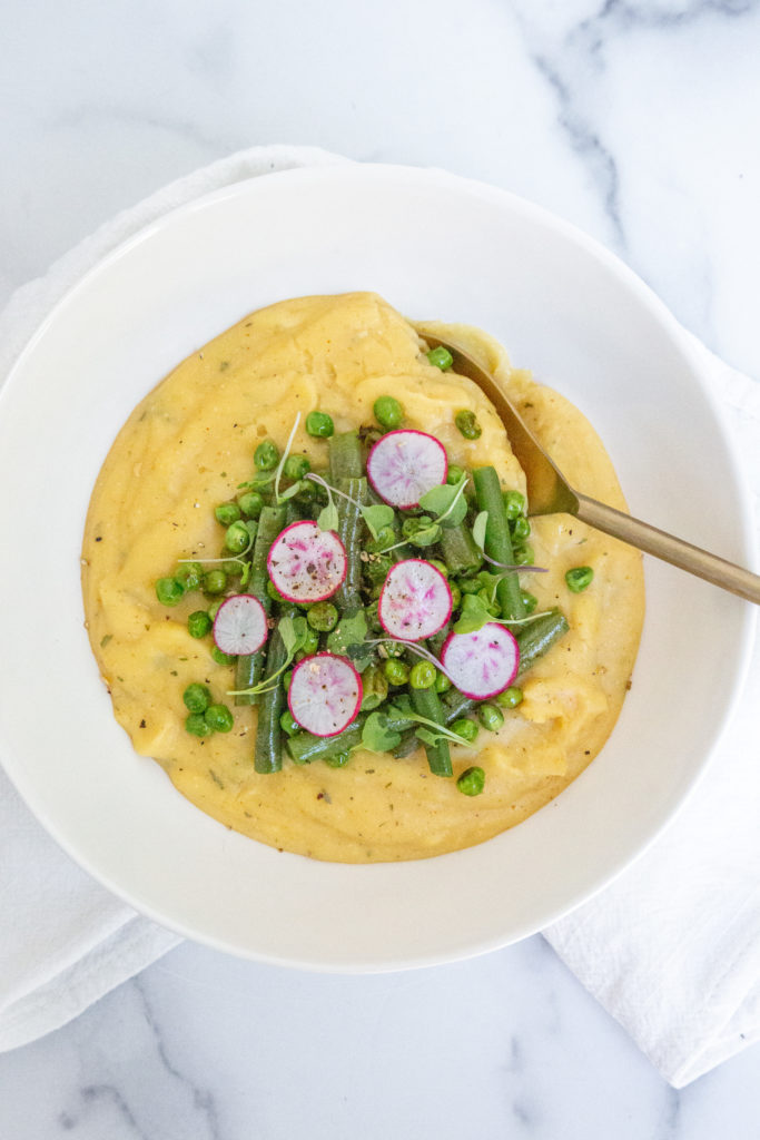 creamy vegetable polenta with green beans, radish, and sprouts