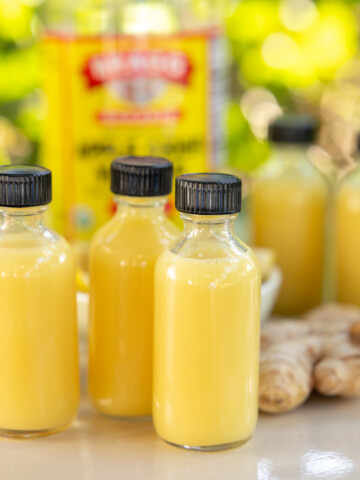 Lemon ginger shots with apple cider vinegar in small glass bottles
