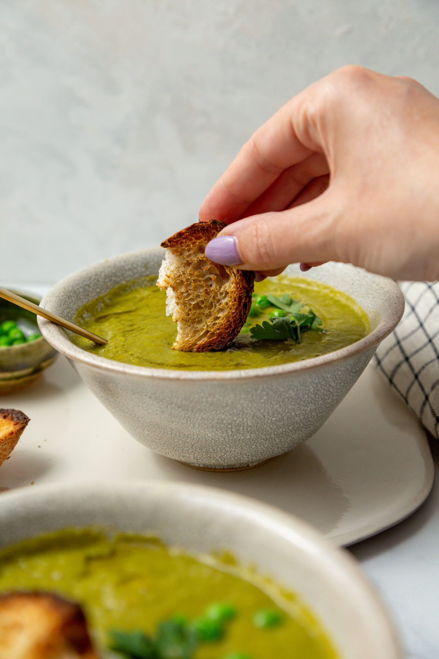 sourdough bread dunking into green soup