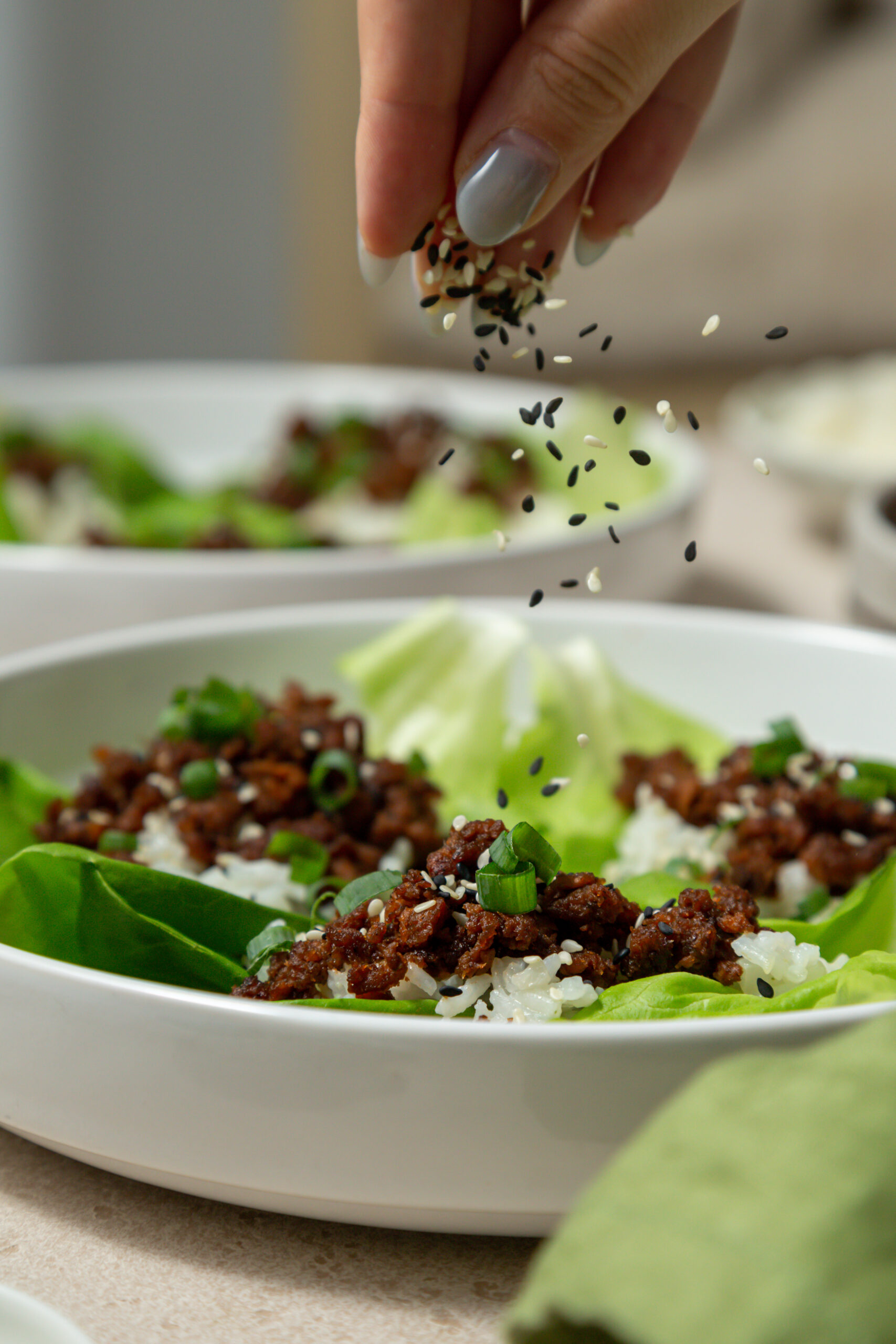 close up sesame seeds sprinkle on lettuce wraps