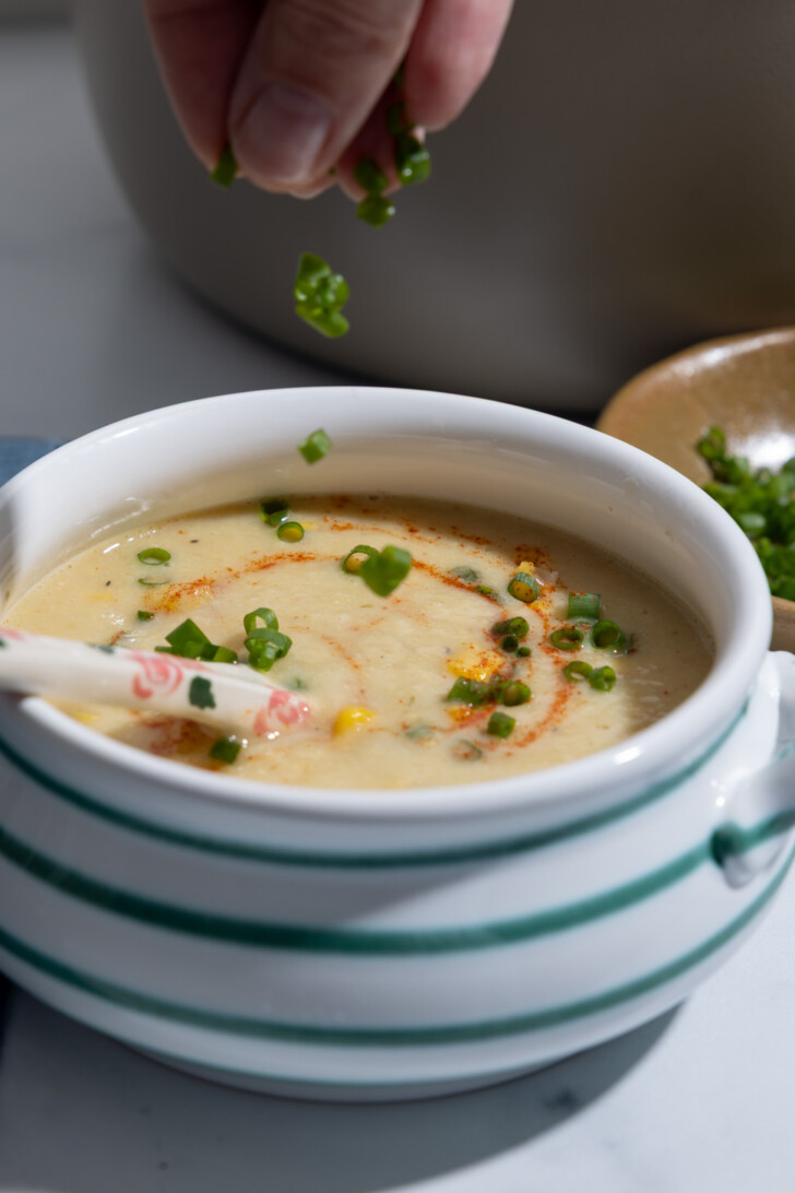 Healthy vegan corn chowder garnished with fresh chives