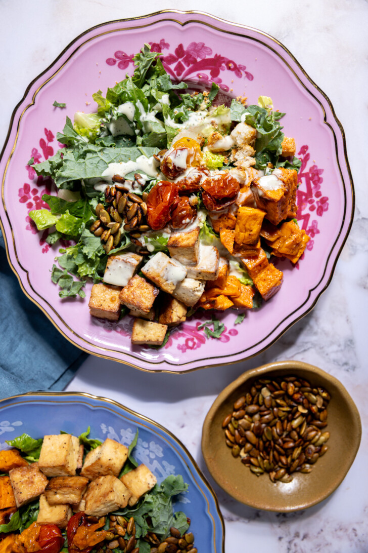 Sweetgreen autumn Caesar copycat salad with hearty fall ingredients and thick vegan Caesar dressing served on a pink floral plate.