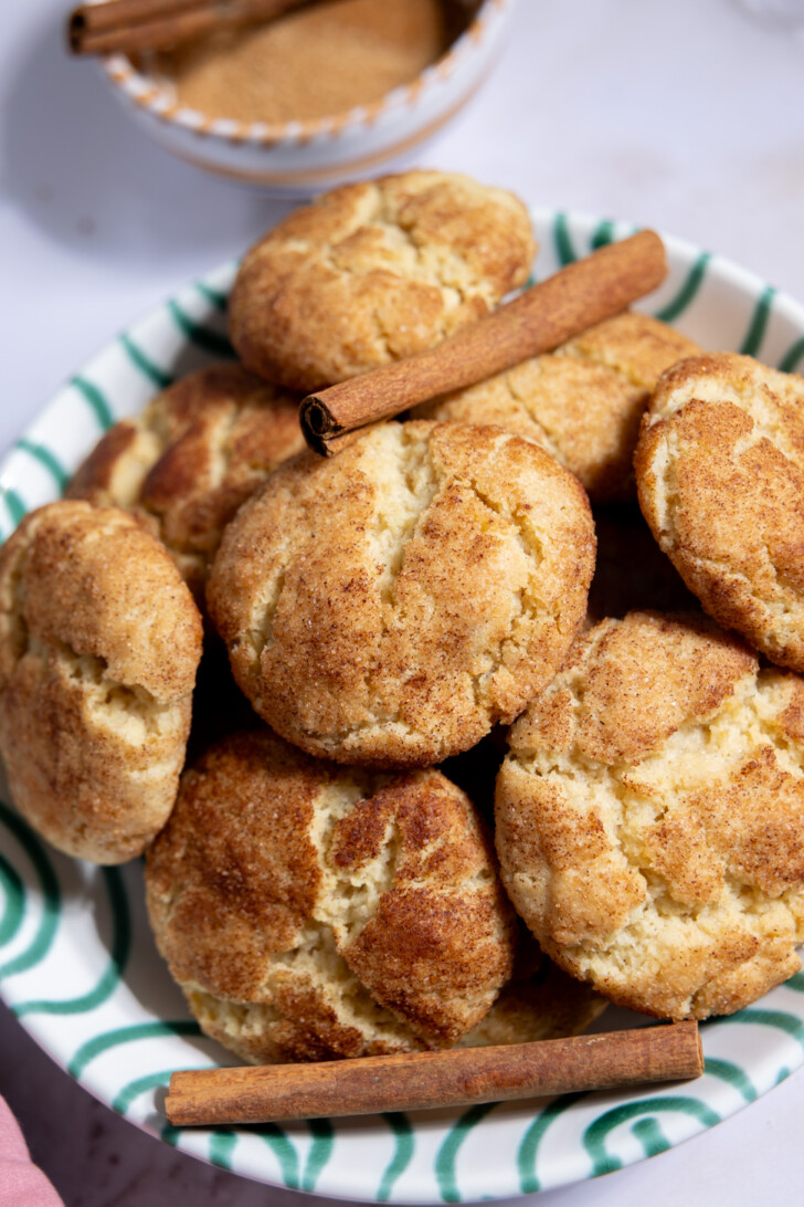 closeup of homemade vegan snickerdoodle cookies with cinnamon sticks