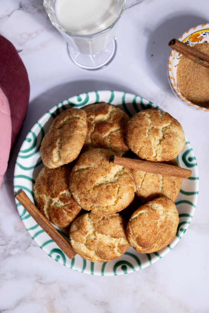 Plate of homemade vegan snickerdoodle cookies with cinnamon sticks