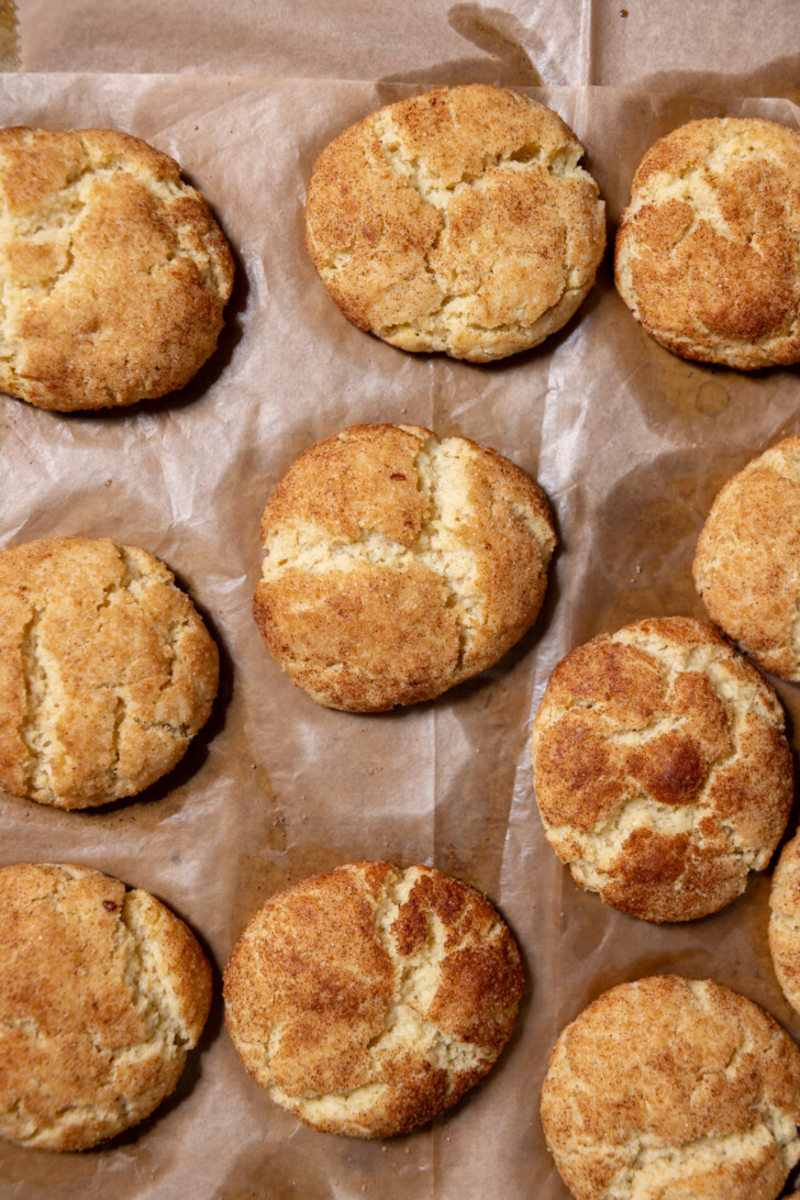 Freshly baked vegan snickerdoodle cookies cooling on parchment paper